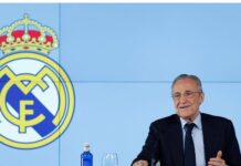 Florentino Pérez, presidente do Real Madrid, acusa Barcelona de enriquecer árbitros da LaLiga O presidente do Real Madrid de terno e gravata preta e camisa branca está à direita da foto. Ao seu lado, na parede o símbolo do Real Madrid.